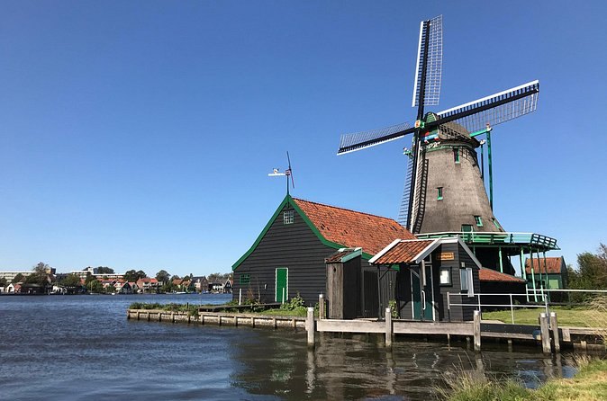 A Zaanse Schans windmill and its timber barn standing at the water's edge