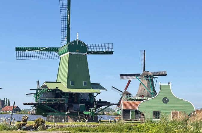 A green-painted Zaanse Schans windmill in front of the rest of the row
