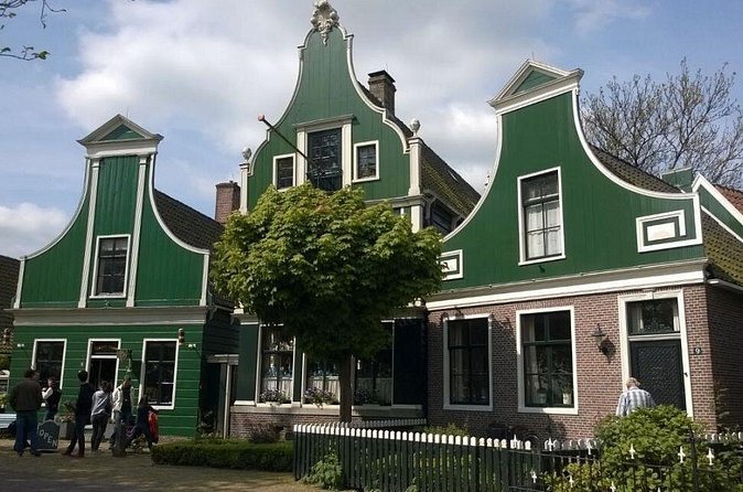 The stepped green timber gables of Zaanse Schans houses against a bright sky