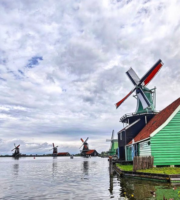 The Zaanse Schans windmills along the water under a heavy grey sky