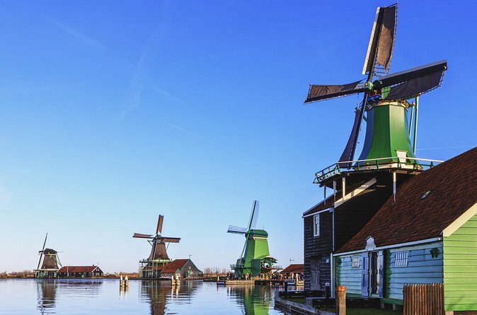Zaanse Schans windmills standing across the water under a blue sky
