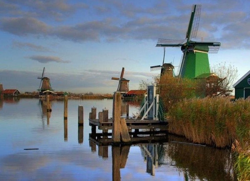Zaanse Schans windmills reflected in still water at dusk