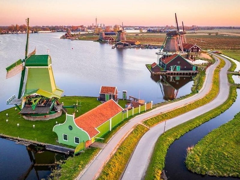 The Zaanse Schans windmills and green timber houses along the River Zaan at sunset, seen from above